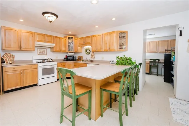 a kitchen with a dining table chairs and refrigerator