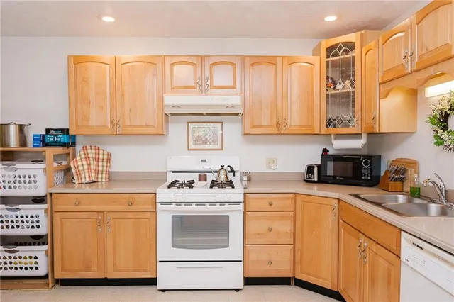 a kitchen with cabinets appliances a sink and a counter top space