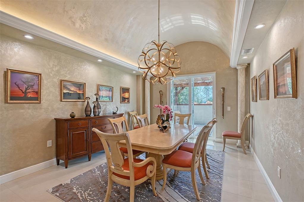 520 Rye Road Northeast Bradenton, FL 34212 - Photo 11 of 88 a dining room with wooden floor a chandelier a wooden table and chairs