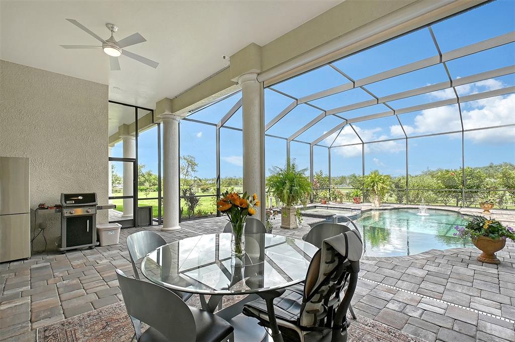 520 Rye Road Northeast Bradenton, FL 34212 - Photo 67 of 88 a dining room with furniture a floor to ceiling window and wooden floor