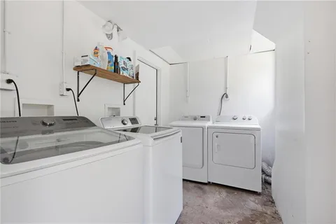 a view of storage and utility room with two washing machine