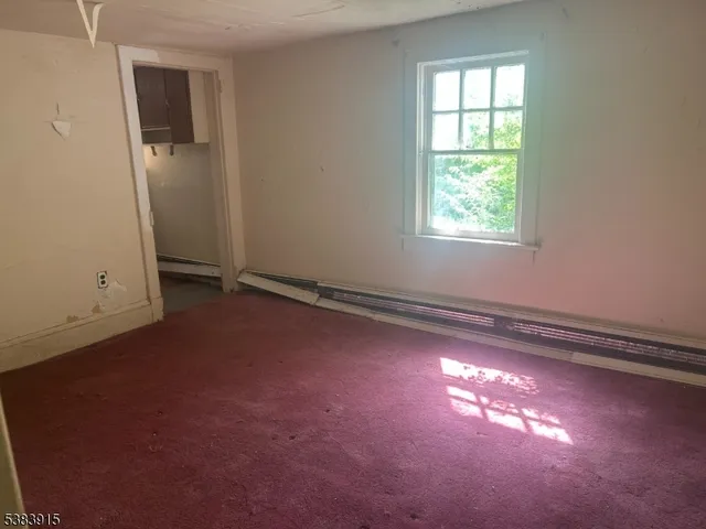 an empty room with windows and closet