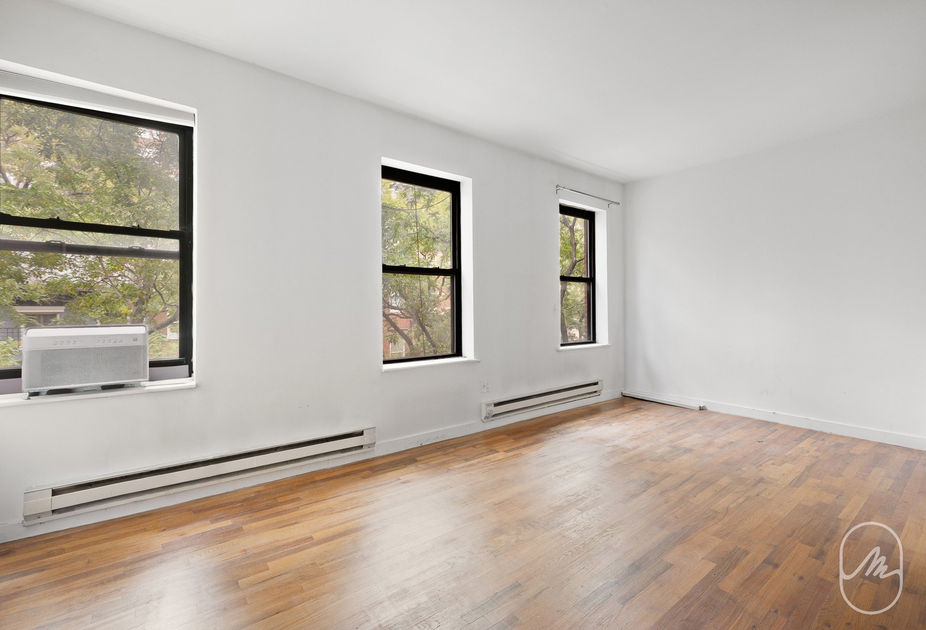 348 West 21st Street, Unit 4F Manhattan, NY 10011 - Photo 2 of 10 a view of an empty room with a window and wooden floor