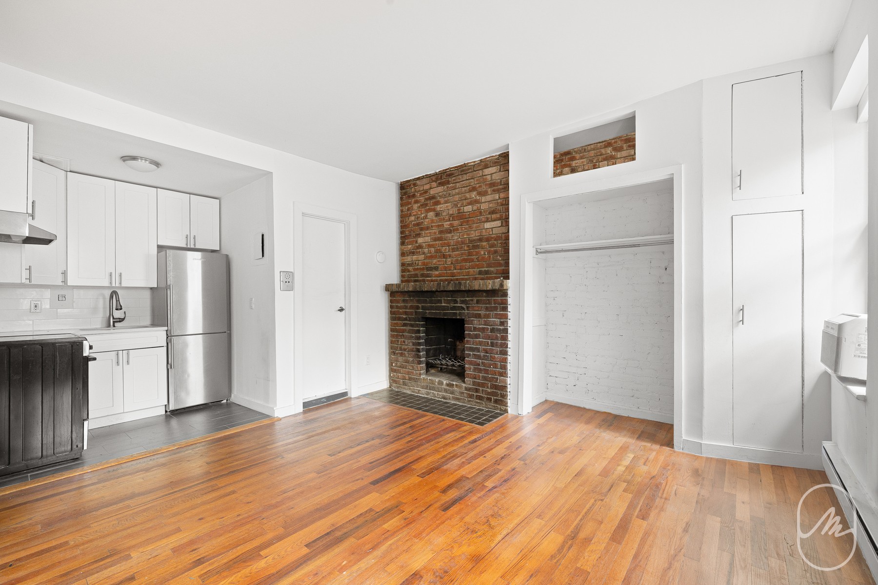 348 West 21st Street, Unit 4F Manhattan, NY 10011 - Photo 6 of 10 a view of a kitchen with wooden floor and a refrigerator