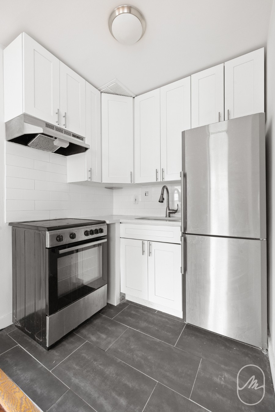 348 West 21st Street, Unit 4F Manhattan, NY 10011 - Photo 8 of 10 a kitchen with stainless steel appliances a refrigerator sink and cabinets
