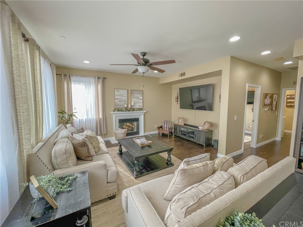 5381 Campania Way Fontana, CA 92336 - Photo 11 of 45 a living room with furniture a fireplace and a flat screen tv