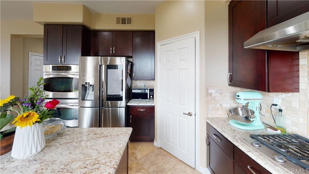 5381 Campania Way Fontana, CA 92336 - Photo 15 of 45 a kitchen with a refrigerator and a sink