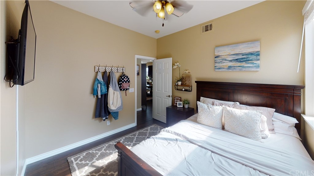 5381 Campania Way Fontana, CA 92336 - Photo 21 of 45 a bedroom with a bed and a chandelier