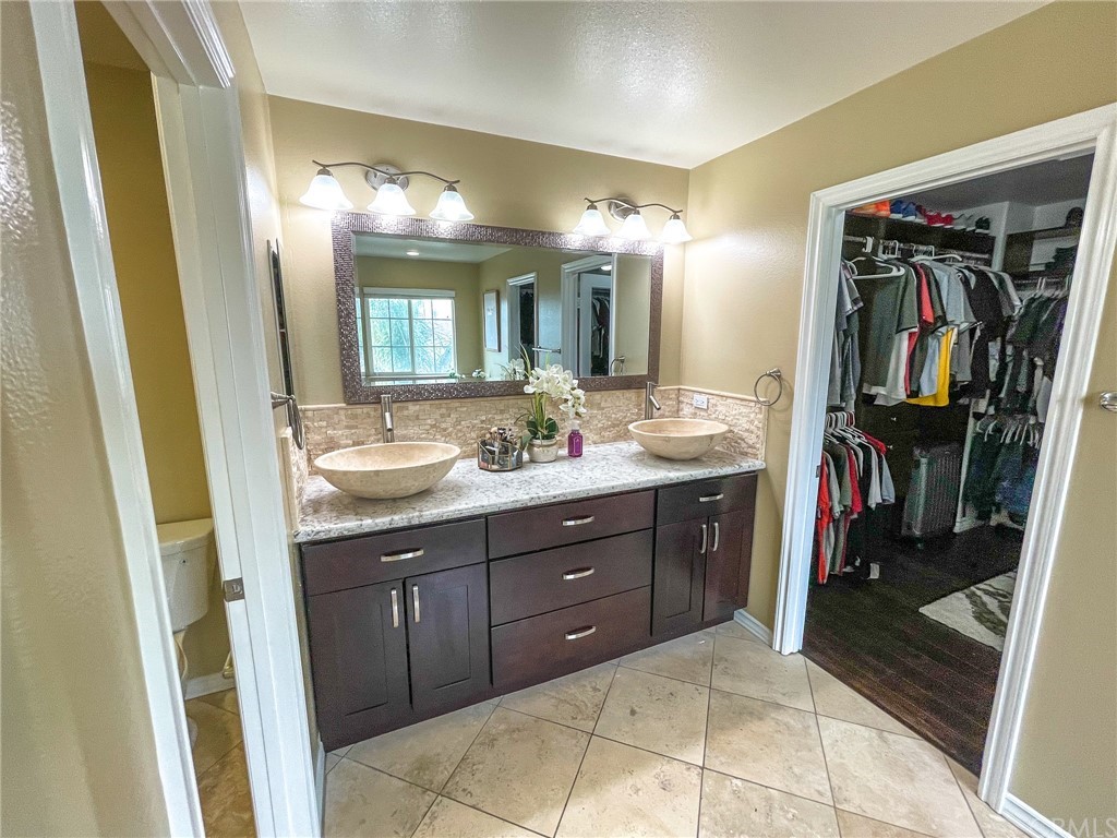 5381 Campania Way Fontana, CA 92336 - Photo 40 of 45 a bathroom with a sink and a mirror