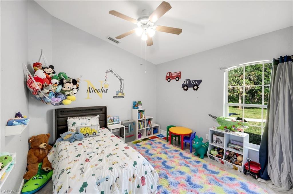 3780 12th Avenue Southeast Naples, FL 34117 - Photo 24 of 43 a bedroom with a bed and a chandelier