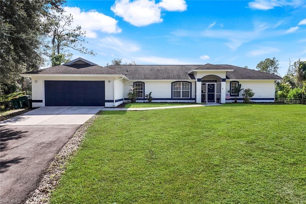 3780 12th Avenue Southeast Naples, FL 34117 - Photo 30 of 43 a front view of a house with a yard and garage