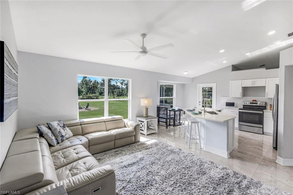 3780 12th Avenue Southeast Naples, FL 34117 - Photo 3 of 43 a living room with furniture a large window and a dining table