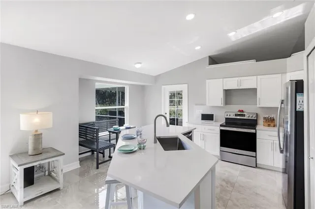 a kitchen with a table chairs refrigerator and cabinets