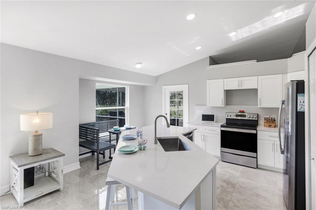 3780 12th Avenue Southeast Naples, FL 34117 - Photo 7 of 43 a kitchen with a table chairs refrigerator and cabinets