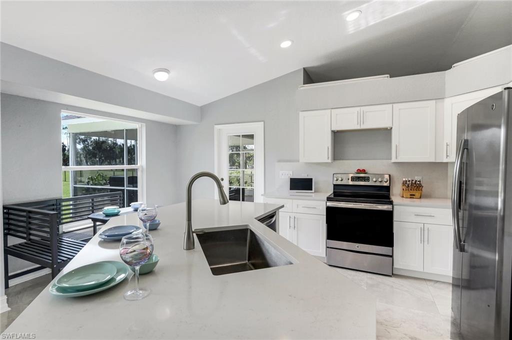 3780 12th Avenue Southeast Naples, FL 34117 - Photo 9 of 43 a kitchen with stainless steel appliances a stove a sink and a microwave