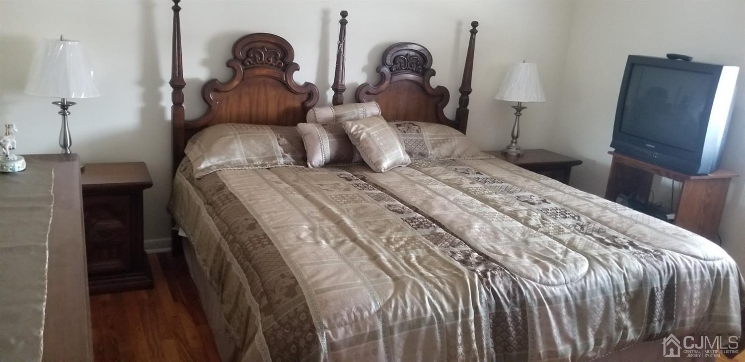 23 Spruce Street Port Reading, NJ 07064 - Photo 15 of 19 a bedroom with a bed and a flat tv screen on the dresser