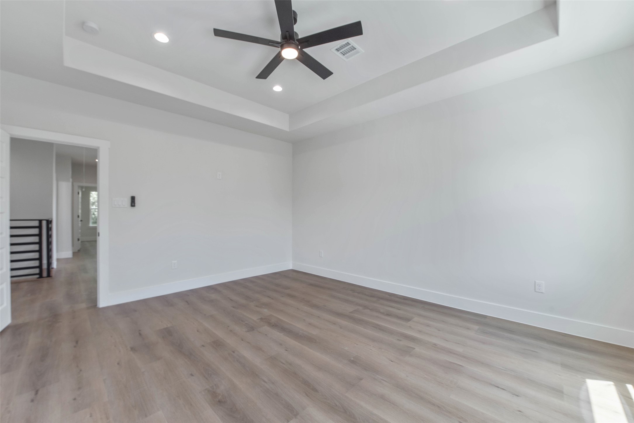 9311 Jutland Road Houston, TX 77033 - Photo 11 of 28 The primary bedroom features a beautifully recessed ceiling, adding depth and architectural interest to the space.