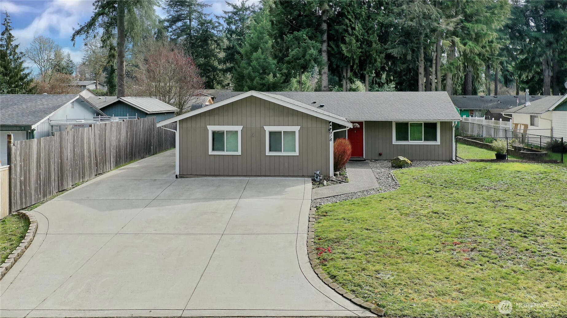 a view of a house with a yard and large tree