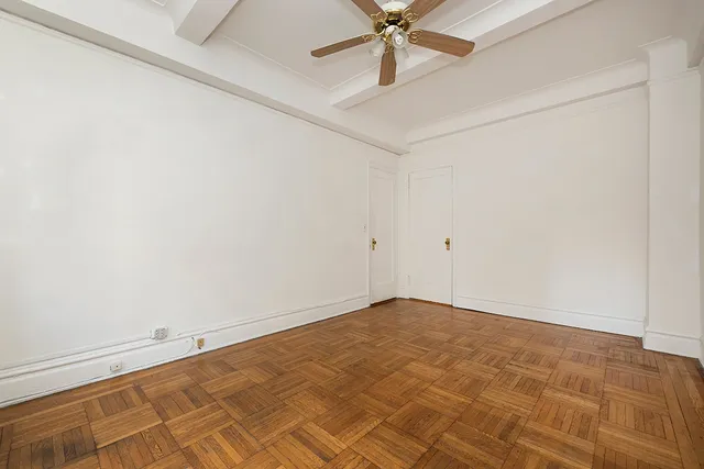 an empty room with a ceiling fan and a window
