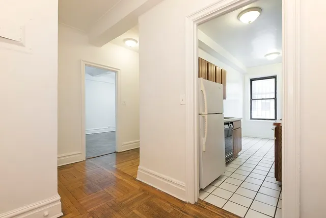 a view of a hallway with wooden floor and closet