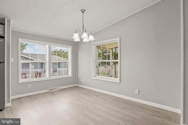 a kitchen with stainless steel appliances granite countertop a stove a sink a refrigerator a microwave and white cabinets