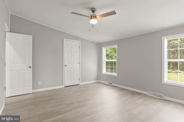a view of an empty room with a ceiling fan