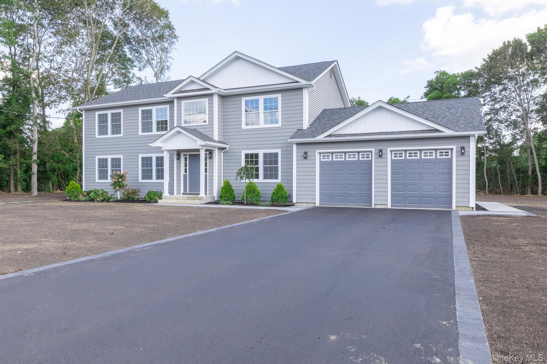 92 Park Street Blue Point, NY 11715 - Photo 2 of 32 a front view of a house with a yard and garage