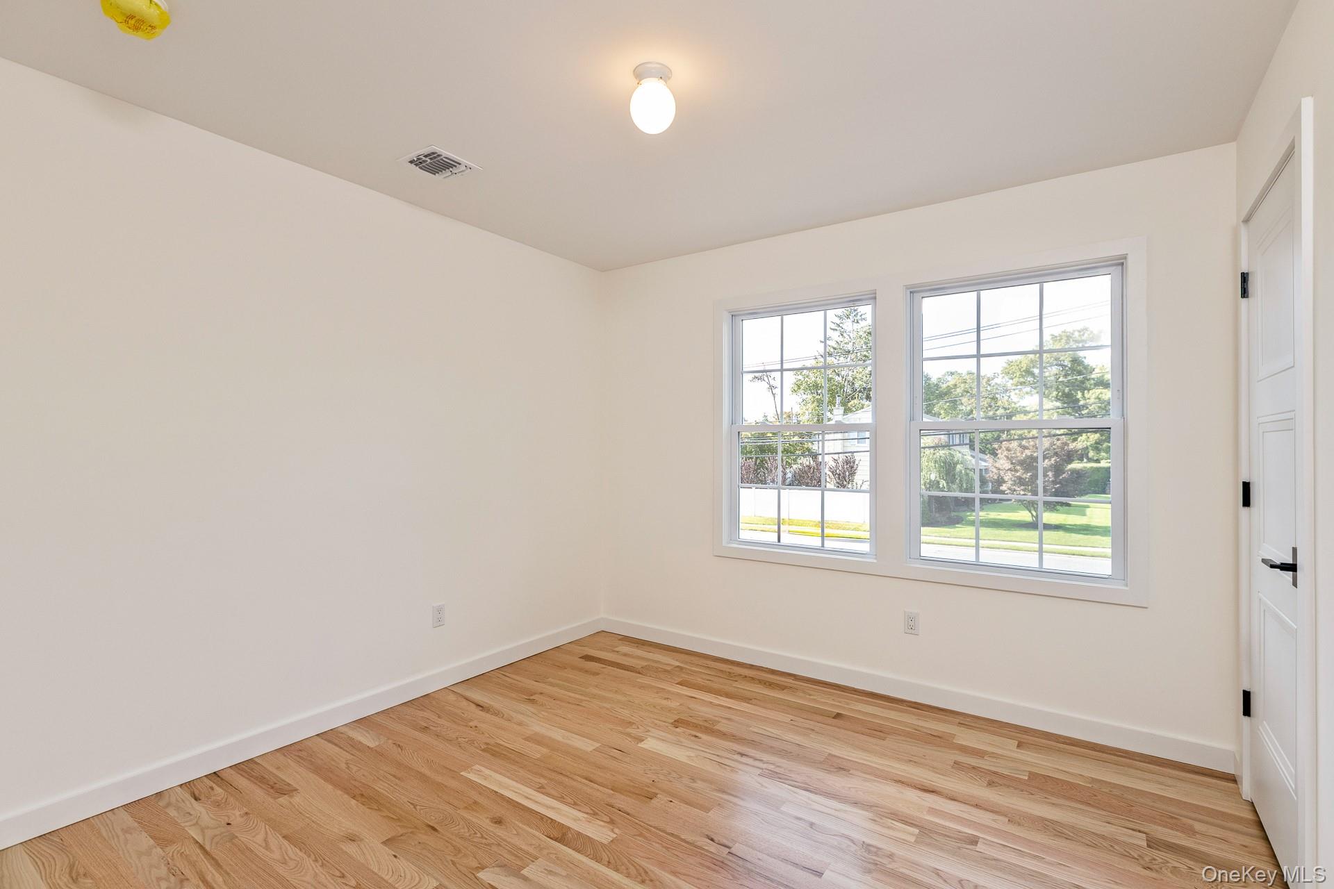 92 Park Street Blue Point, NY 11715 - Photo 26 of 32 an empty room with wooden floor and windows
