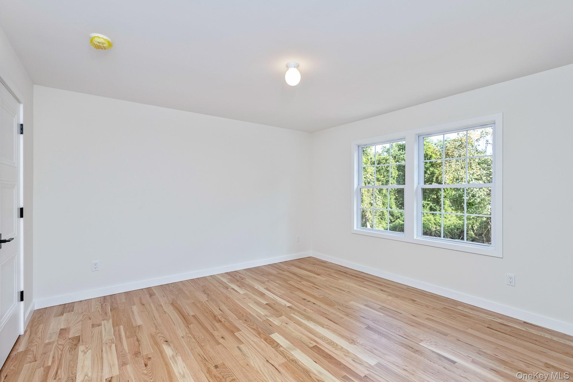 92 Park Street Blue Point, NY 11715 - Photo 29 of 32 an empty room with wooden floor and window