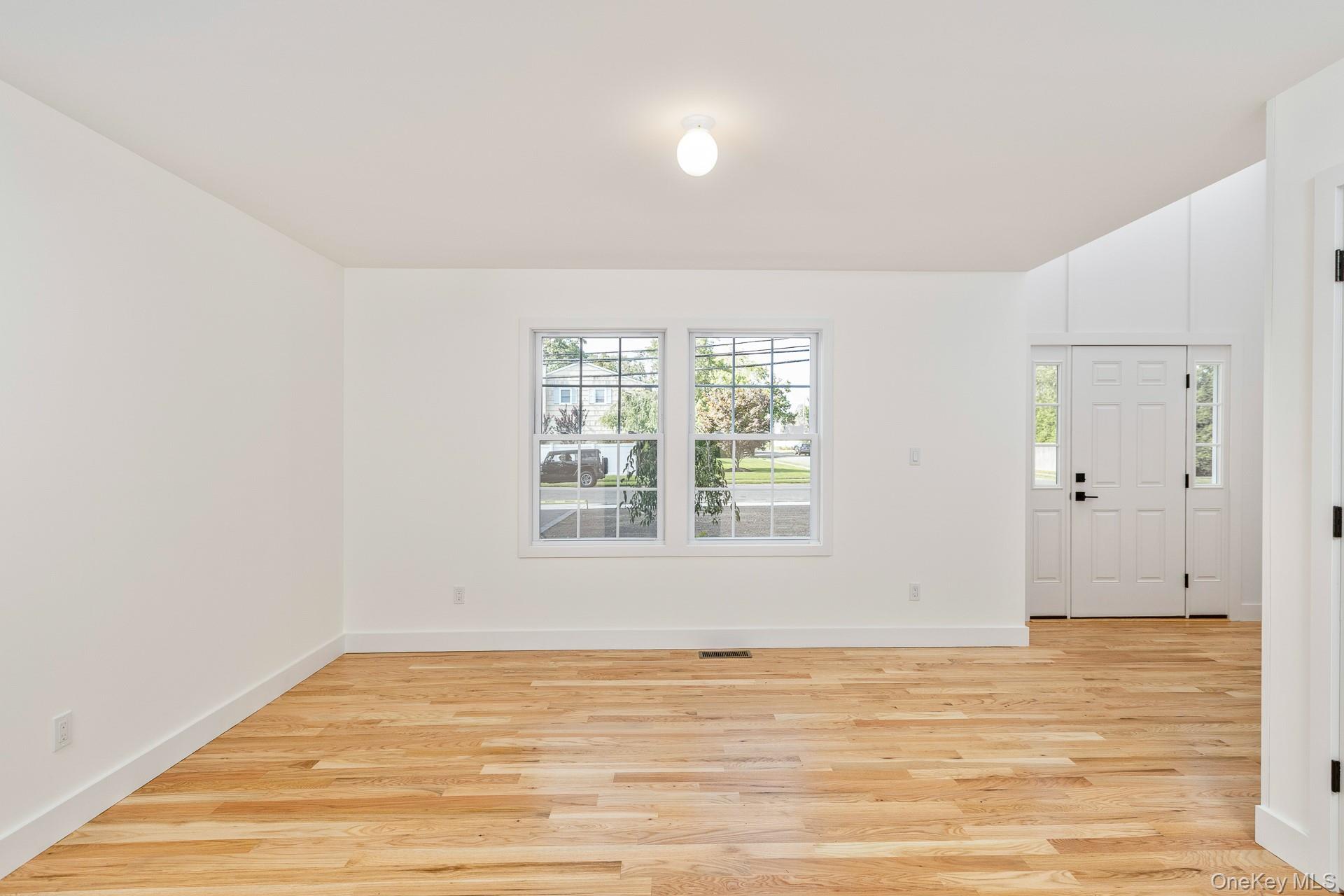 92 Park Street Blue Point, NY 11715 - Photo 10 of 32 a view of an empty room with wooden floor and a window