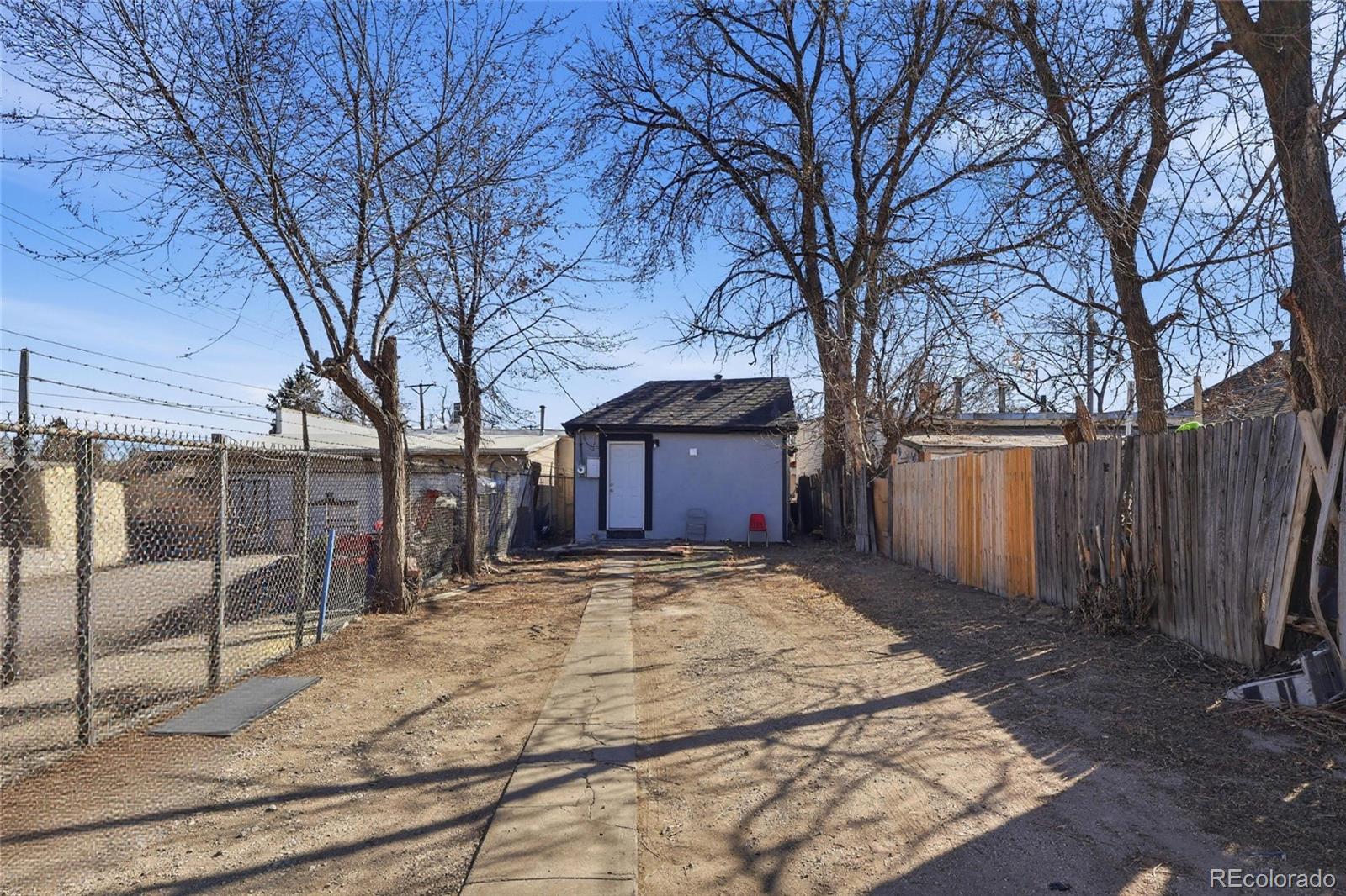 165 Hooker Street Denver, CO 80219 - Photo 11 of 11 a tree is standing in front of a house