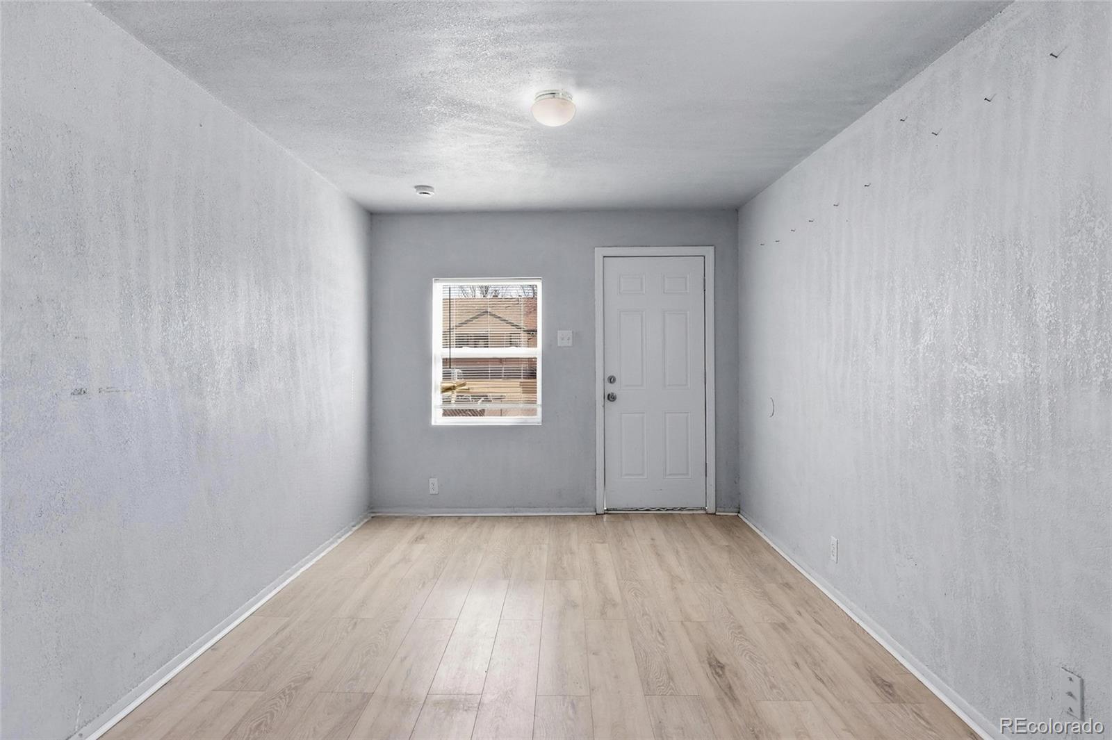 165 Hooker Street Denver, CO 80219 - Photo 2 of 11 an empty room with wooden floor and windows