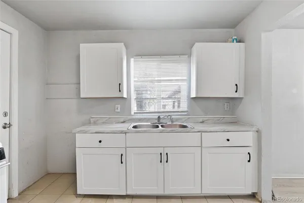 a sink with white cabinets