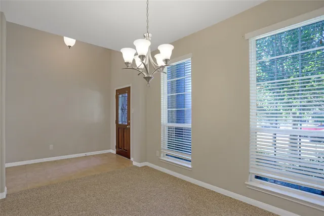 a view of a livingroom with a chandelier curtains and large windows