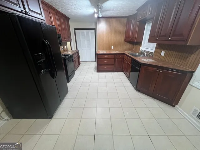 a large kitchen with a stove a refrigerator and a sink