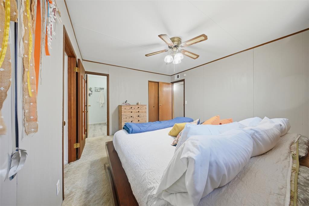 610 Walter Road Gainesville, TX 76240 - Photo 12 of 33 a bedroom with a bed and a chandelier