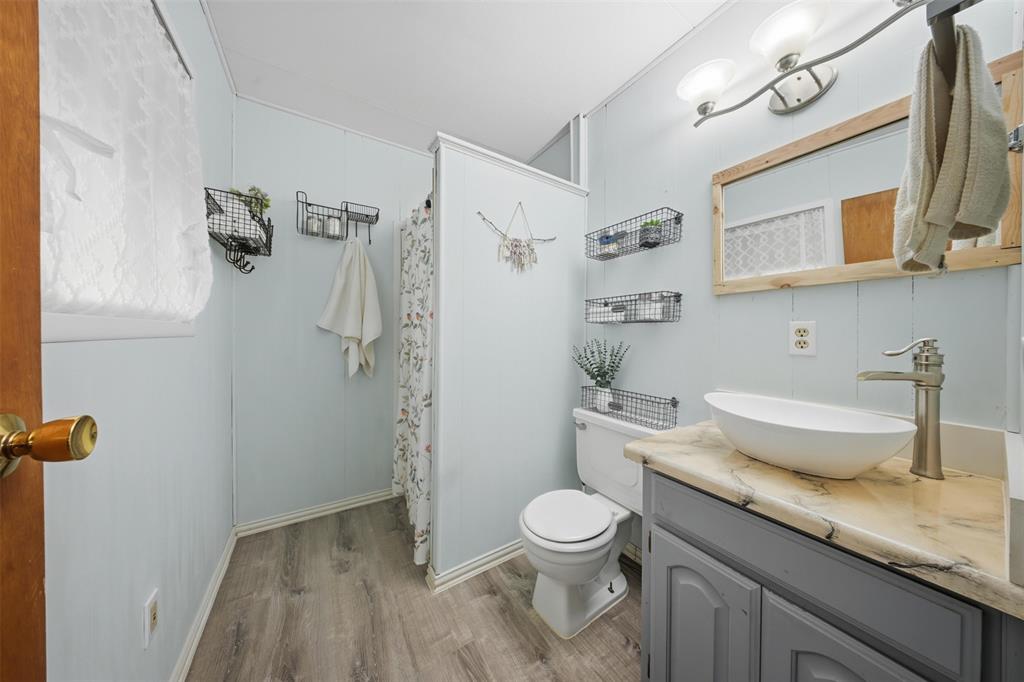610 Walter Road Gainesville, TX 76240 - Photo 13 of 33 a bathroom with a granite countertop sink toilet and shower