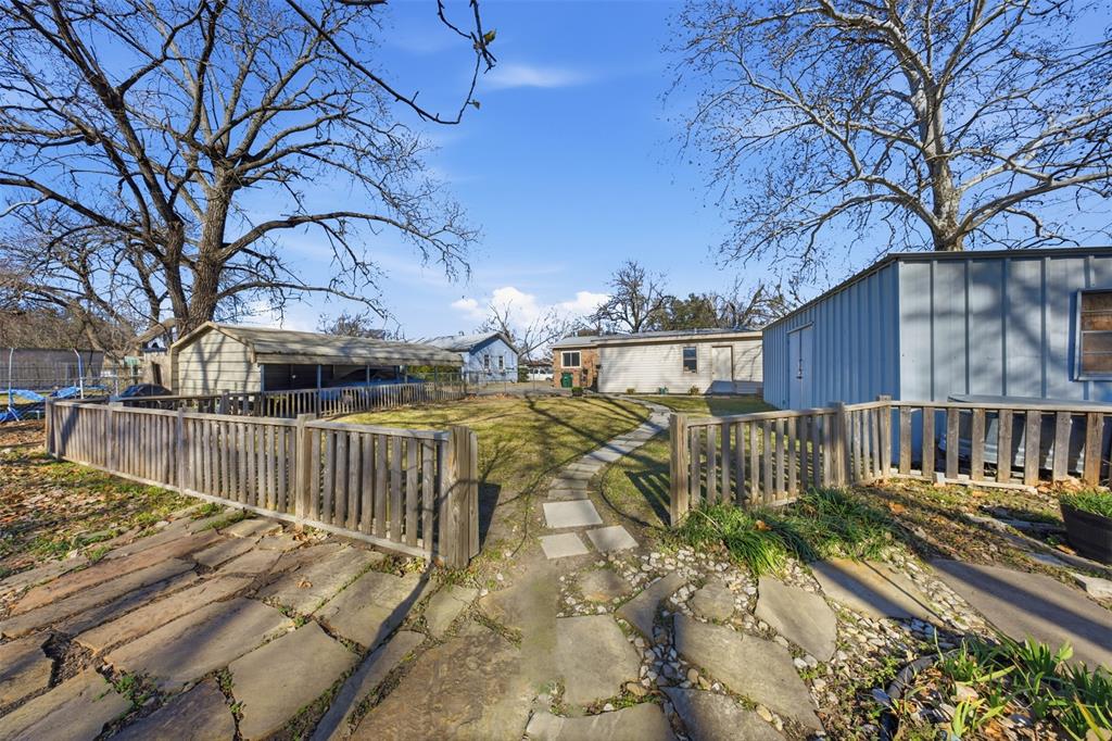 610 Walter Road Gainesville, TX 76240 - Photo 30 of 33 a view of a house with a wooden fence next to a yard