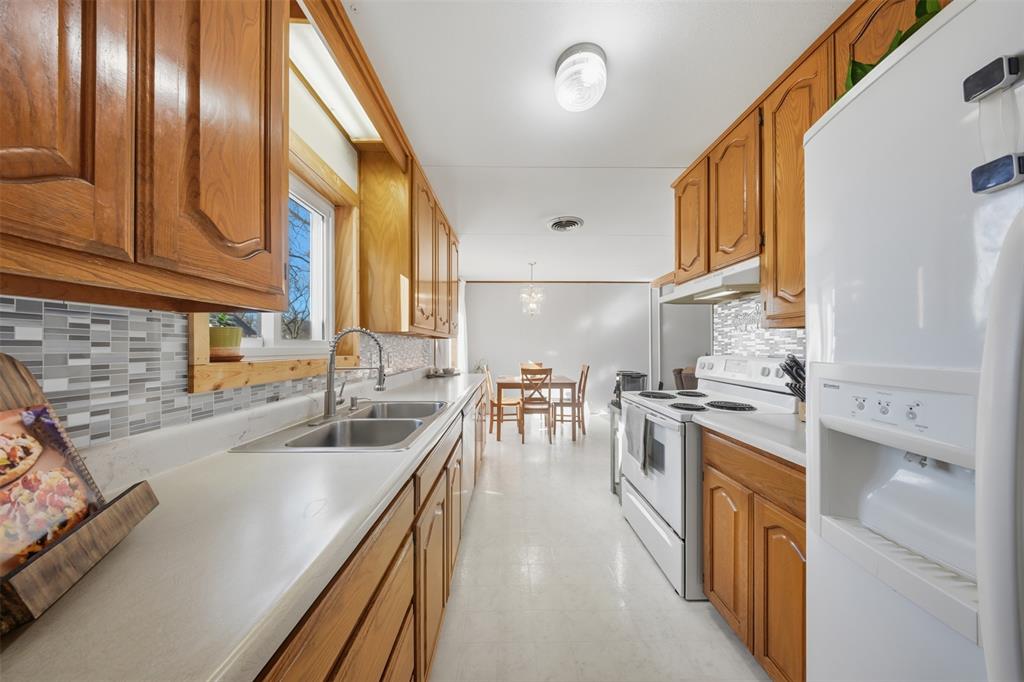 610 Walter Road Gainesville, TX 76240 - Photo 3 of 33 a kitchen with stainless steel appliances granite countertop a sink a stove and a refrigerator