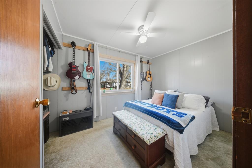 610 Walter Road Gainesville, TX 76240 - Photo 5 of 33 a bedroom with a bed and a chandelier