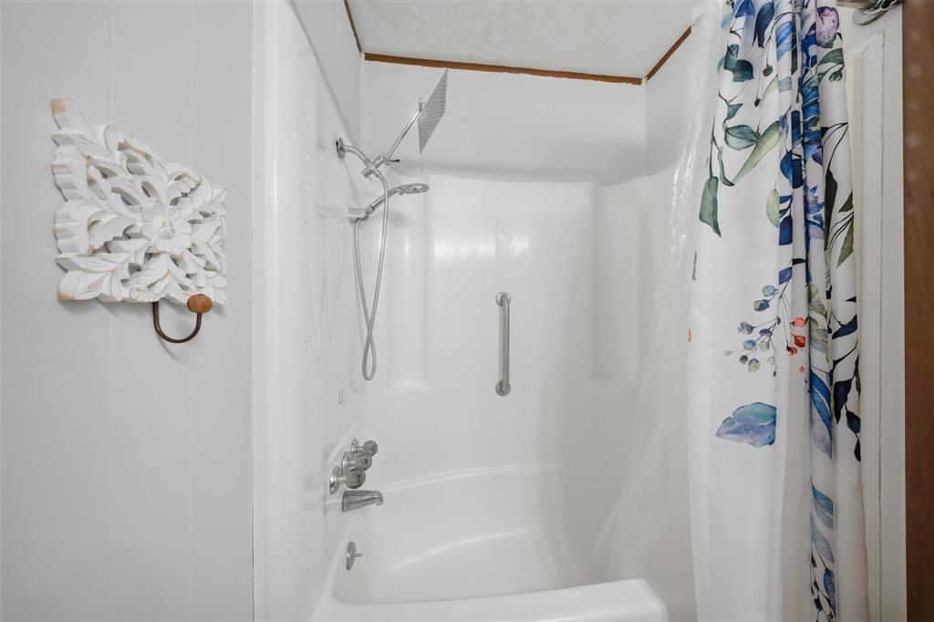 610 Walter Road Gainesville, TX 76240 - Photo 8 of 33 a bathroom with a shower curtain