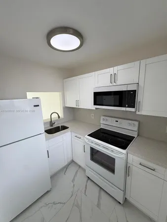 a kitchen with cabinets and white appliances
