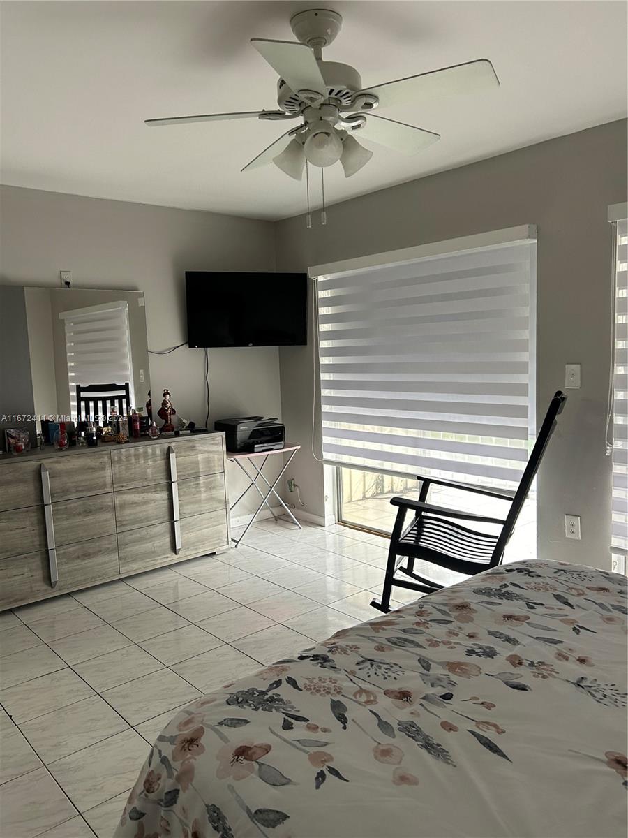 West End Miami, FL 33193 - Photo 14 of 19 a bedroom with furniture and a lamp