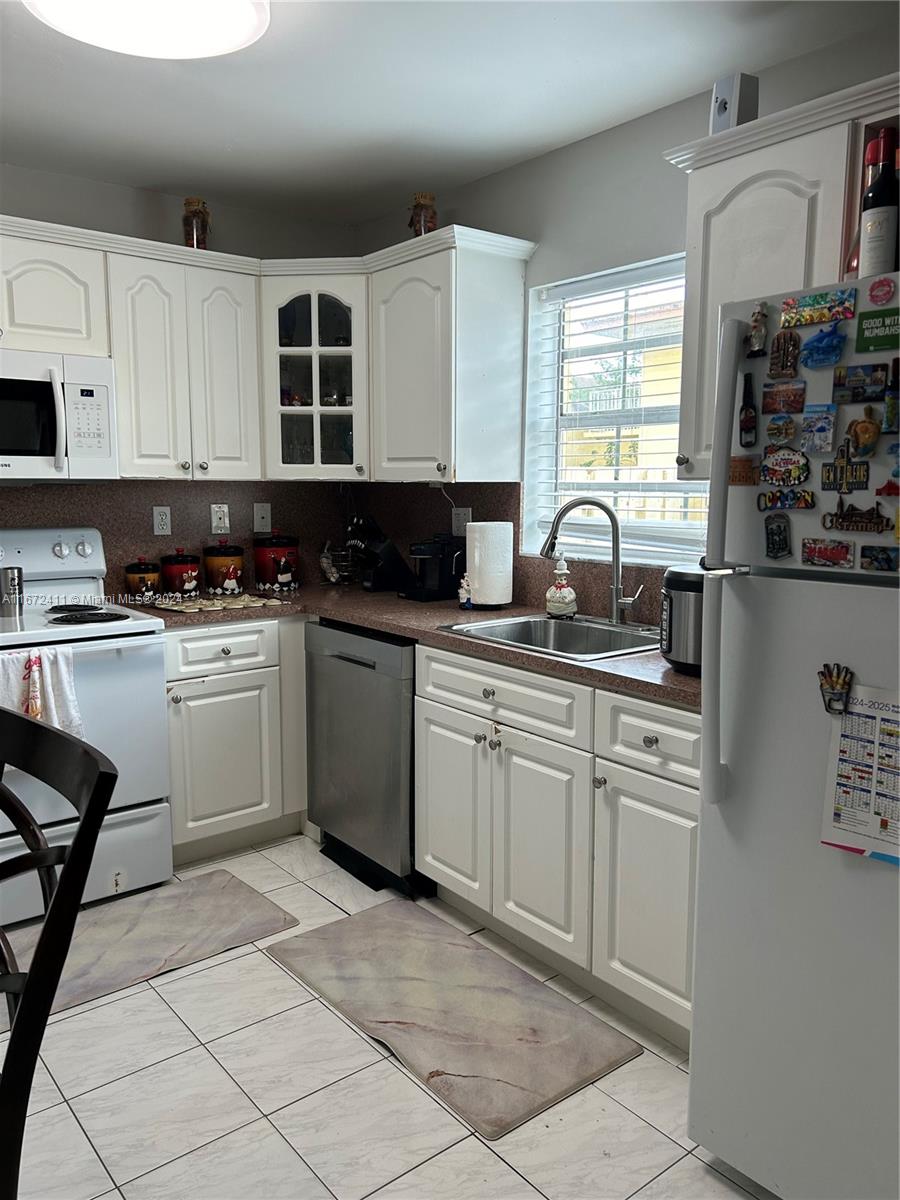 West End Miami, FL 33193 - Photo 9 of 19 a kitchen with a sink stove top oven and cabinets