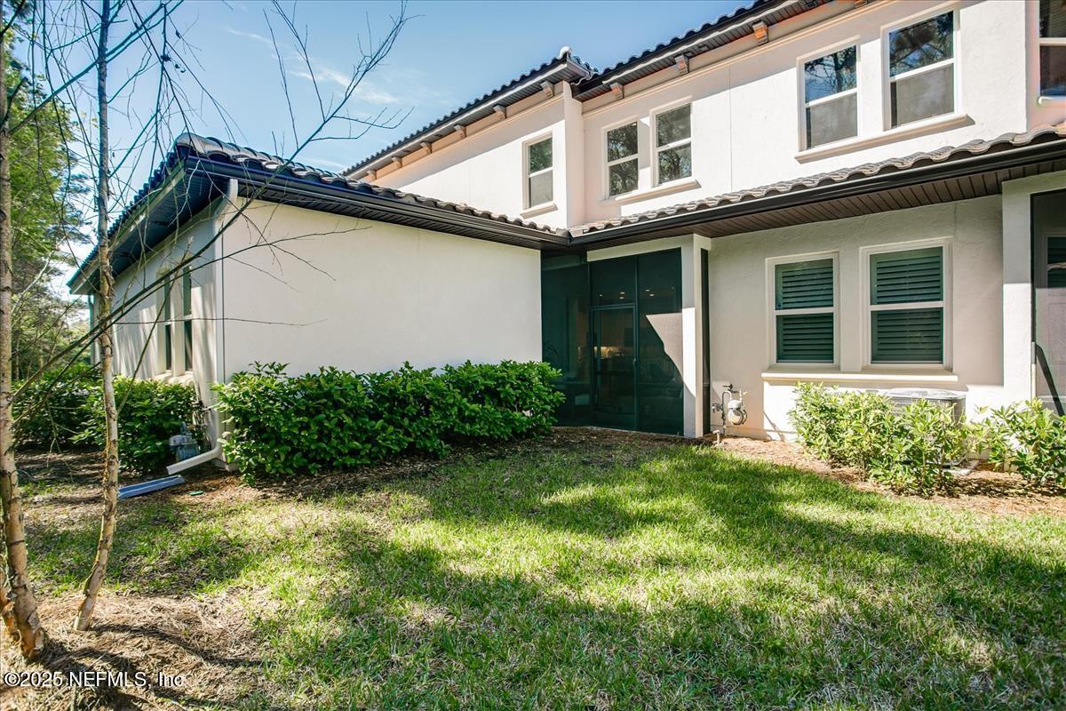 109 Rimini Court Jacksonville, FL 32225 - Photo 23 of 27 a view of a house with brick walls and a yard with plants