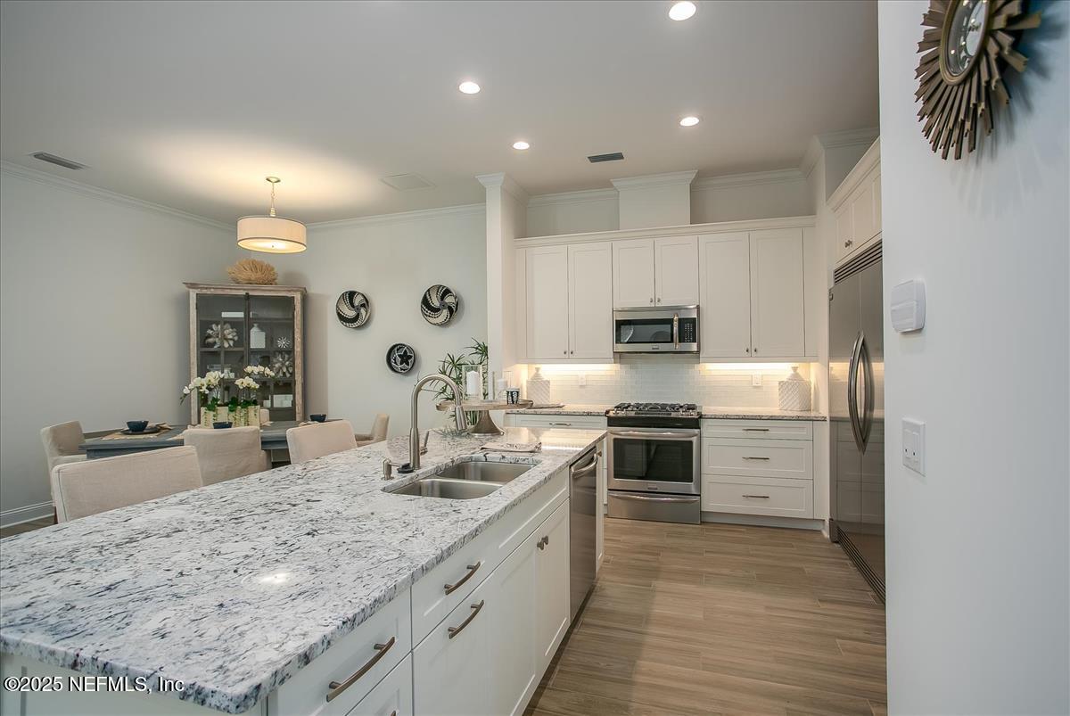 109 Rimini Court Jacksonville, FL 32225 - Photo 9 of 27 a kitchen with stainless steel appliances granite countertop a stove top oven a sink dishwasher and a refrigerator with wooden floor