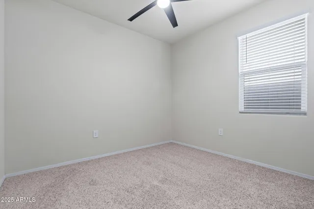 a view of an empty room with closet and wooden door