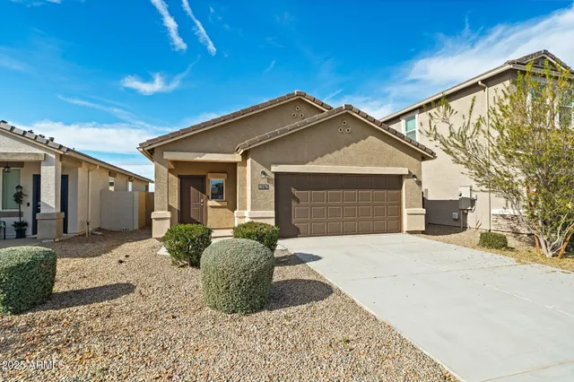 a front view of a house with a yard and potted plants