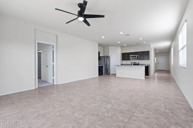 a kitchen with granite countertop kitchen island stainless steel appliances a sink stove and refrigerator
