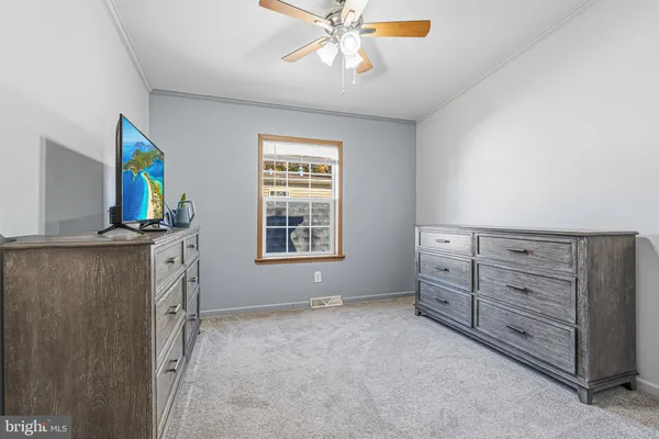 a view of an empty room with a window and dresser